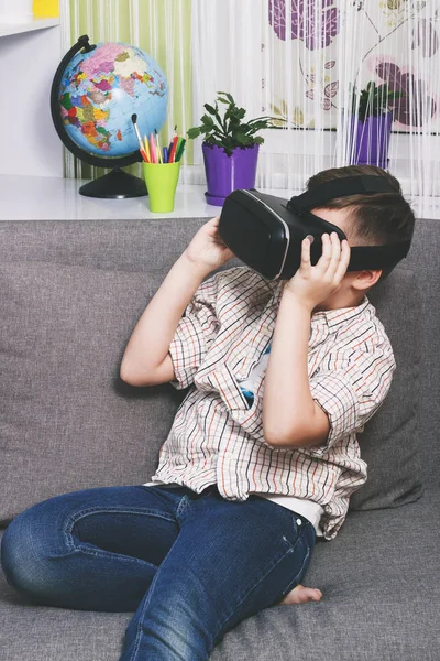 Menino brinca com óculos de realidade virtual, dentro de casa. Dispositivo de realidade virtual digital — Fotografia de Stock