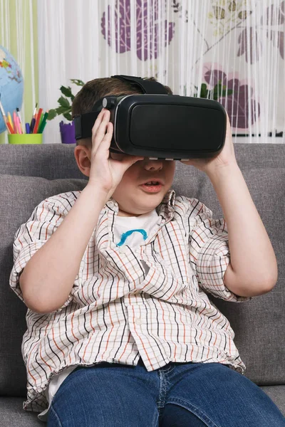 Niño juega con gafas de realidad virtual, en el interior. Dispositivo de realidad virtual digital — Foto de Stock