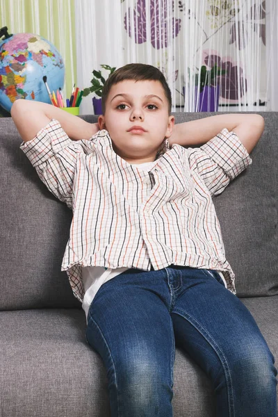 Boy sits on the sofa, soft focus background