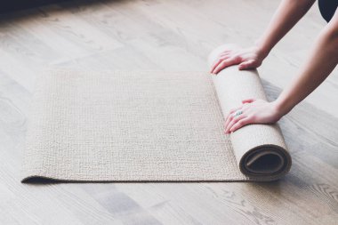 Yoga dersinden sonra paspası yuvarlanan kadın.