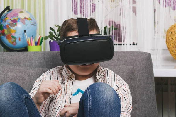 Niño juega con gafas de realidad virtual, en el interior. Dispositivo de realidad virtual digital — Foto de Stock