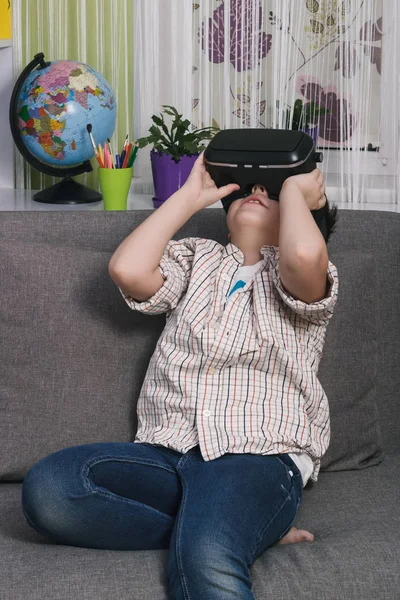 Boy is het bekijken van video met een virtual reality bril, binnenshuis. Digitale virtuele realiteit apparaat — Stockfoto