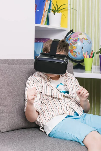 Boy está viendo vídeo con gafas de realidad virtual, en el interior. Dispositivo de realidad virtual digital —  Fotos de Stock