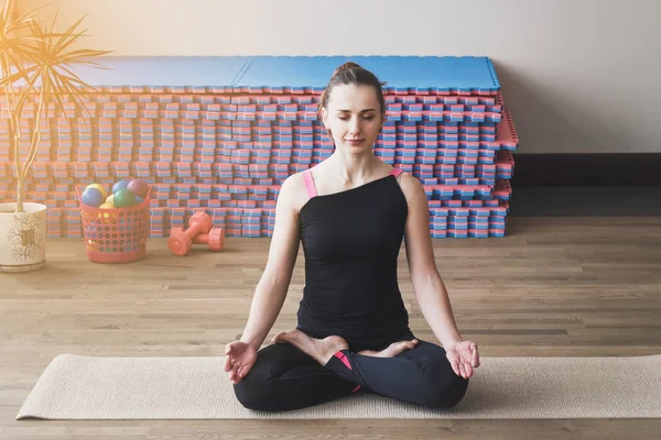 La mujer hace el ejercicio de yoga en la esterilla — Foto de Stock