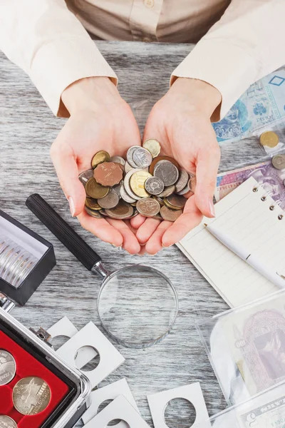 Mujer con diferentes monedas en las palmas — Foto de Stock