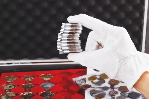 Mano en el guante sostiene monedas de colección en las cajas —  Fotos de Stock