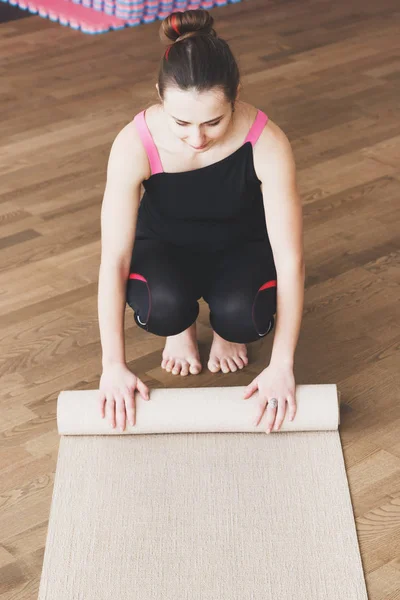 Vrouw maakt de yoga oefening op de mat, binnenshuis — Stockfoto