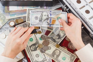 Bir büyüteç ve Amerikan Doları ile el