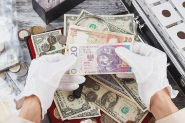 Farklı para birimi ile beyaz eldiven elinde