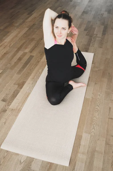 Donna fa l'esercizio di yoga sul tappeto, in casa — Foto Stock