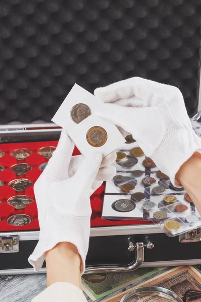 Las manos en los guantes sostienen volteretas con moneda de colección — Foto de Stock