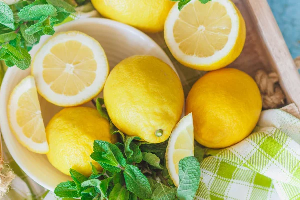 Жовті лимони з листя м'яти, дерев'яний фон — стокове фото