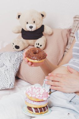 Plaka üzerinde farklı çörek ile hamile kadın