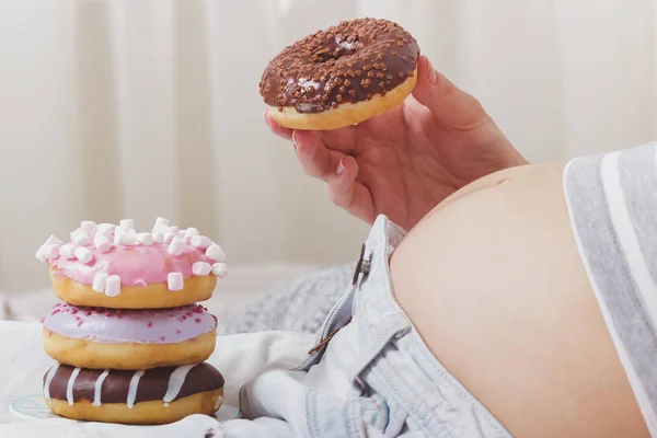 stock image Pregnant woman with different donuts on the plate