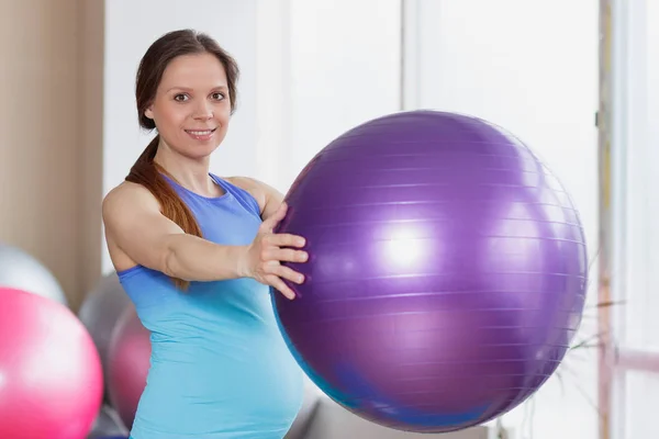Egzersiz topu elinde olan hamile sportif kadın — Stok fotoğraf