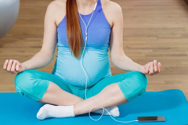 Mujer embarazada hace ejercicio de yoga en la esterilla en el gimnasio — Foto de Stock