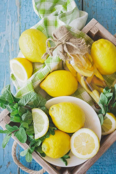 Жовті лимони з листя м'яти на дерев'яному фоні — стокове фото