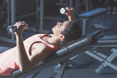 Sportif kadın spor egzersizleri dumbbells ile yapar