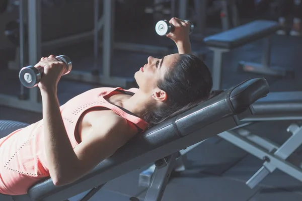 Sportif kadın spor egzersizleri dumbbells ile yapar — Stok fotoğraf