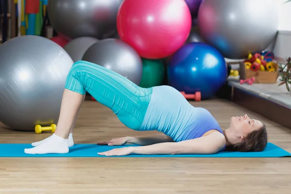 Donna incinta fa esercizio sul tappeto — Foto Stock