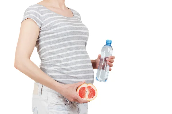 Беременная женщина с грейпфрутом в руках — стоковое фото