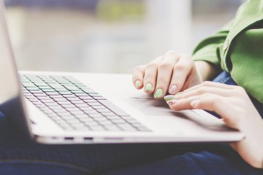 Dizüstü bilgisayardaki kadının elleri, yumuşak odaklı arka plan.