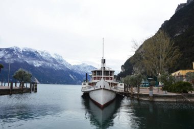 Bir Riva Del Garda, İtalya - 3 Mart 2016: Lake Garda moor gemi ve dağ yatay, kar, kış saati, Riva del Garda, İtalya ile görünümünü şaşırtıcı