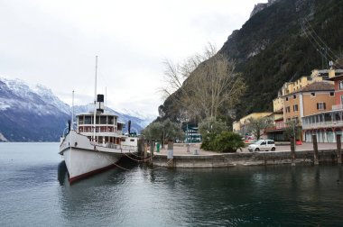 Bir Riva Del Garda, İtalya - 3 Mart 2016: Lake Garda moor gemi ve dağ yatay, kar, kış saati, Riva del Garda, İtalya ile görünümünü şaşırtıcı