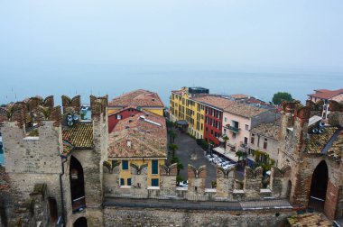 View of Sirmione town from the castle with fog Lake Garda in Italy  clipart