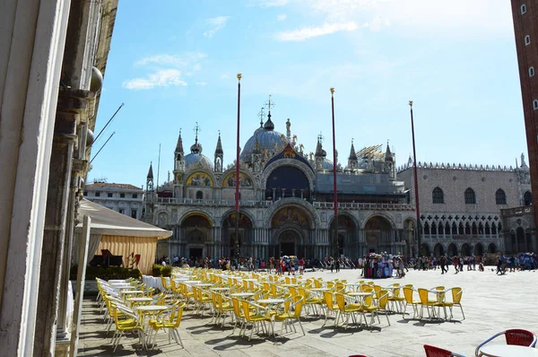 Praça de São Marcos Veneza com Basílica de São Marcos em dia ensolarado, mesas e cadeiras de um restaurante com turistas no fundo, Veneza, Itália verão 2016 — Fotografia de Stock