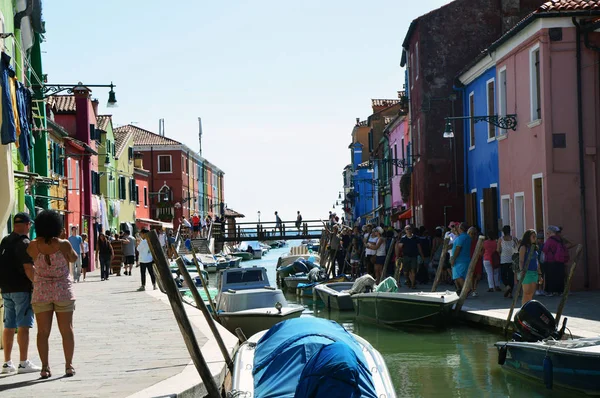 Venezia Burano ricca di turisti con le sue tipiche case colorate, barche e ponte sul fondo, nel pomeriggio di sole, Venezia, Italia estate 2016 — Foto Stock