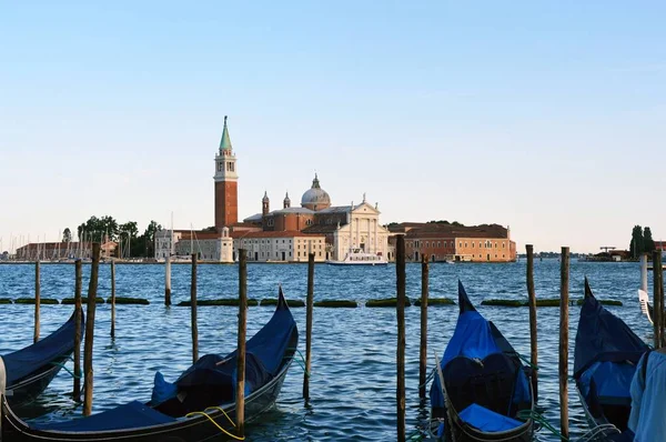 Venedik ticari marka Lagoon gondol yakın çekim ve Venedik kilisenin altındaki günbatımı, Venedik, İtalya yaz 2016 — Stok fotoğraf