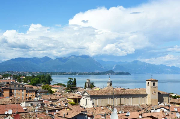 デゼンツァーノ ・ デル ・ ガルダ、イタリア - 2017 年 5 月 15 日: 驚くべき都市の古い屋根、山、白い雲湖、デゼンツァーノ ・ デル ・ ガルダ、イタリアのヨットとガルダ湖でデゼンツァーノ城からのパノラマ — ストック写真