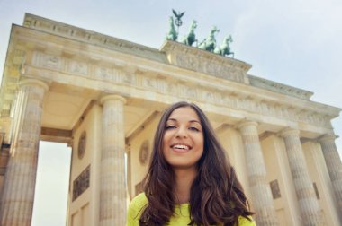 Brandenburg Kapısı, Berlin, Almanya önünde mutlu gülümseyen kız. Güzel ve genç birbayan seyahat Avrupa'da.