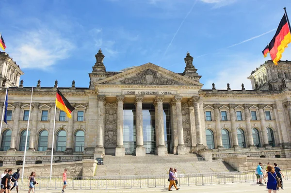 Německá vlají ve větru na Reichstag building, sídlo německého parlamentu (Deutscher Bundestag), za slunečného dne se modrá obloha a mraky, Berlín, Německo — Stock fotografie