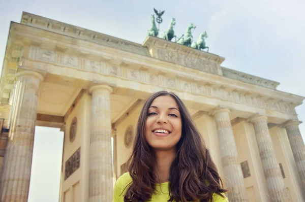 Szczęśliwy uśmiechający się dziewczyna przed Bramą Brandenburską, Berlin, Niemcy. Piękna młoda kobieta podróży w Europie. — Zdjęcie stockowe