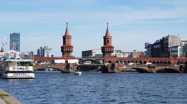Pohled na řeku Spree od Schillingbrcke mostu s žlutým vlakem na Oberbaumbrücke na pozadí, Berlín, Německo — Stock fotografie