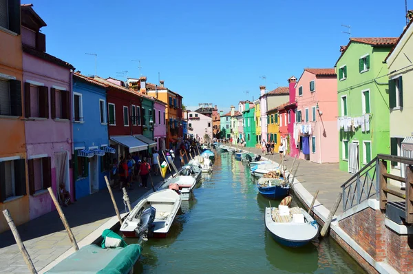 Typical brightly colored houses and narrow channels with tourists in Burano, Venice, Italy — Stock Photo, Image