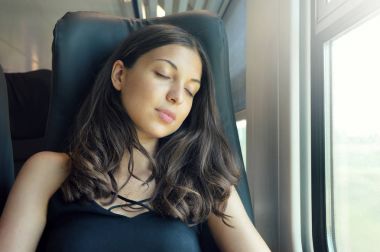 Trende oturan uyuyan genç güzel kadın. Bir koltukta oturuyor ve uyku seyahat tren yolcu. 