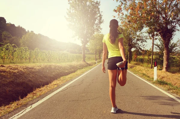 Başarı için hazır. Kadın figürü germe kazanmak için gidiyor. Kadın runner road koşu elbiseleri günbatımı sokak fitness güneş spor giyim çapraz flare. Başarı kavramı. — Stok fotoğraf