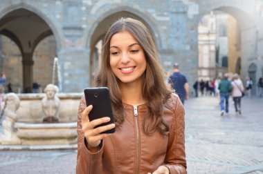 Kentsel arka planda akıllı telefon kullanan güzel kız