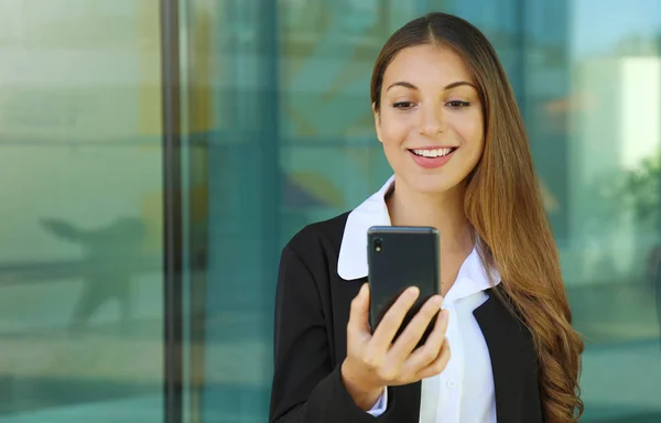 Mulher de negócios verificando seu telefone inteligente fora do escritório . — Fotografia de Stock