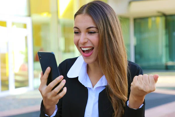 Mujer de negocios exitosa leyendo buenas noticias en el teléfono inteligente y celebrar sentirse feliz . —  Fotos de Stock