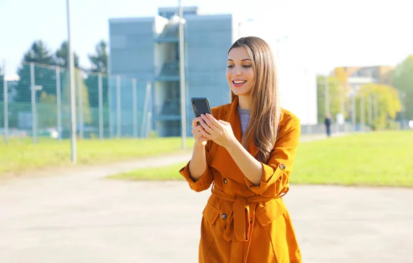 젊은 여자 가 야외에서 스마트 폰 앱으로 메시지를 입력하는 모습 — 스톡 사진