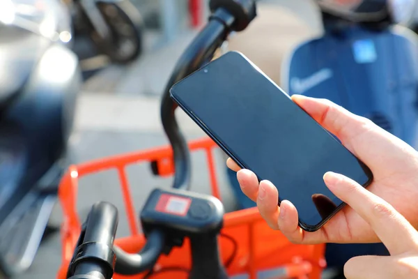 Shared bikes. Hand using smartphone scanning the QR code of shared bike in city.