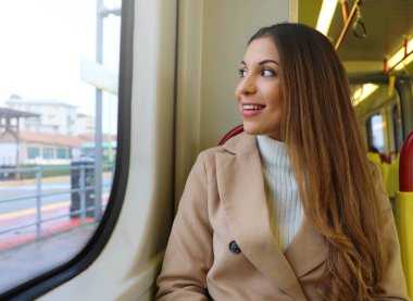 Tramvayda oturan pencereden bakan genç kız.