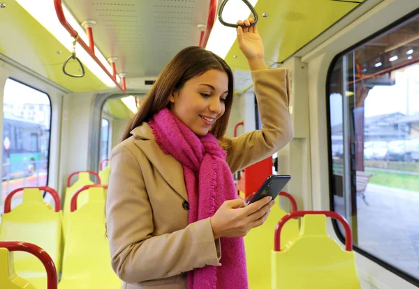 Gente en transporte público. Hermosa joven escribiendo en su teléfono inteligente en el tranvía . — Foto de Stock