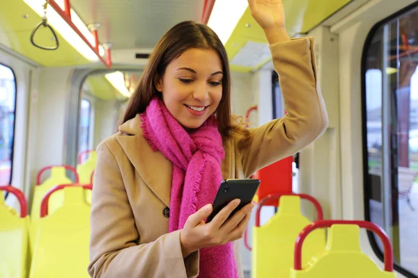 Gente en transporte público. Hermosa joven leyendo el mensaje en el teléfono móvil en el tranvía . — Foto de Stock