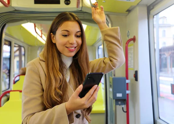 Gente en transporte público. Hermosa joven mujer de negocios leyendo el mensaje en su teléfono inteligente en el tranvía . — Foto de Stock