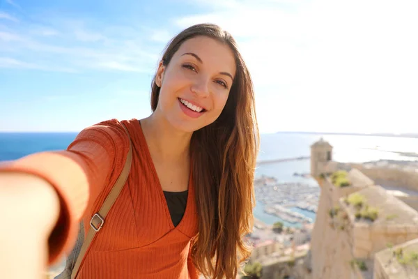 Gülümseyen güzel turist kadın Alicante, İspanya 'da selfie çekiyor. Alicante 'deki Santa Barbara kalesinde resim çeken gezgin kız Avrupa' daki İspanyol turizm beldesi. — Stok fotoğraf